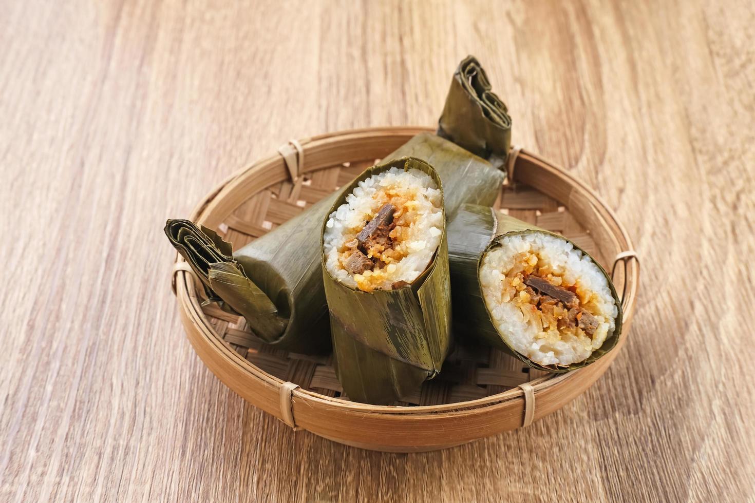 Arem-arem, a traditional Indonesian food made from rice filled with vegetables, chicken, meat or tempeh wrapped in banana leaves. Arem-arem is popular as a breakfast substitute. Selected focus. photo