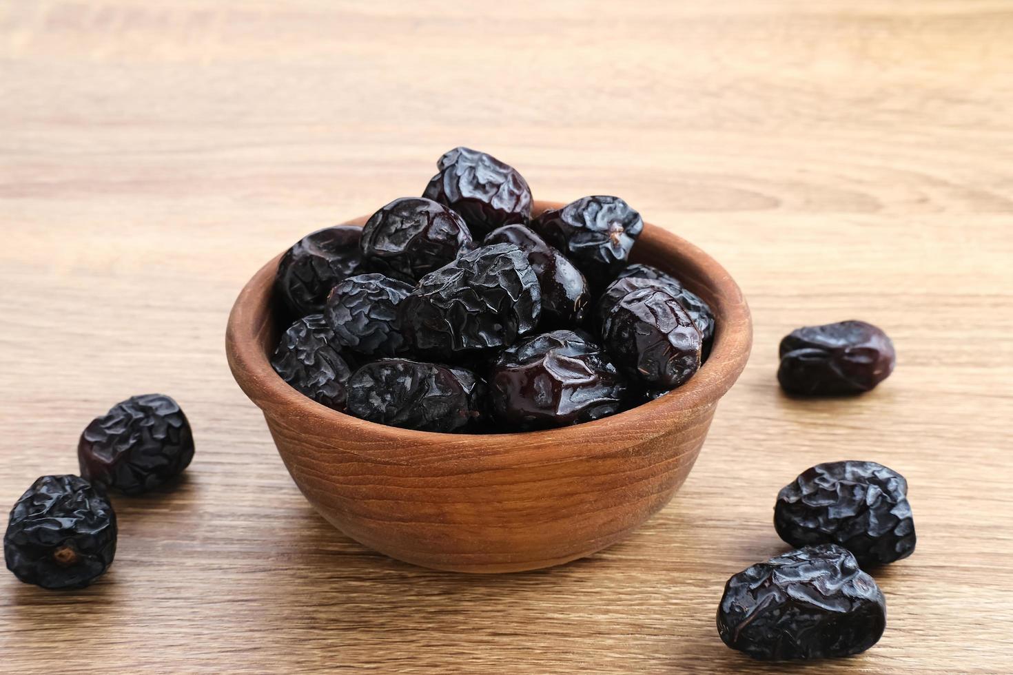 Kurma Ajwa, Ajwa Dates, served in wooden bowl. Kurma Ajwa is one of the special fruit of Arabic. photo