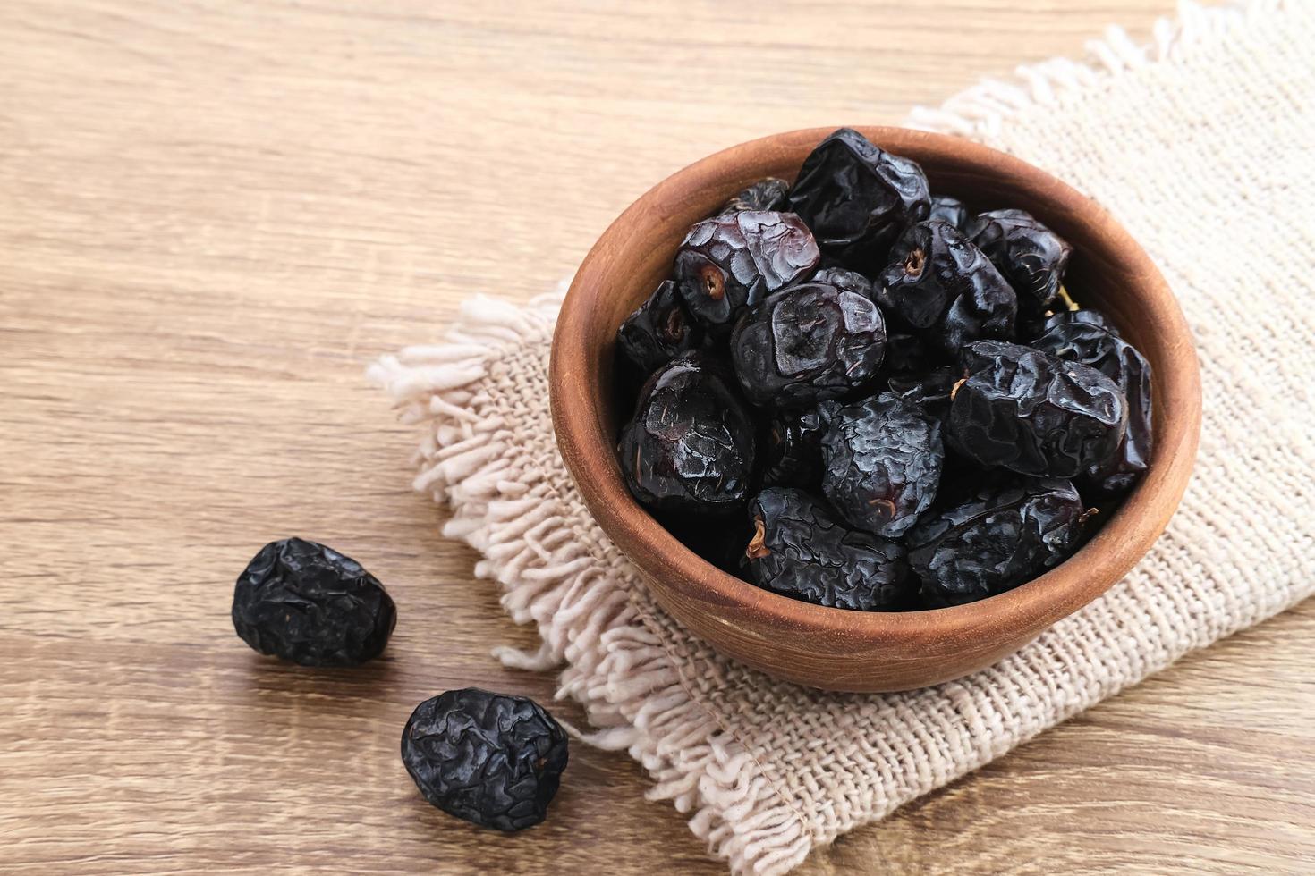 Kurma Ajwa, Ajwa Dates, served in wooden bowl. Kurma Ajwa is one of the special fruit of Arabic. photo