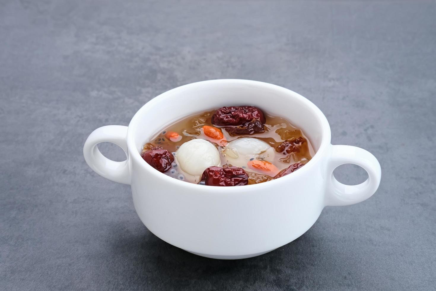 cocina china, un plato de chicle de durazno. El chicle de melocotón es una bebida tradicional china que contiene chicle de melocotón, nido de pájaro, dátiles rojos, hongo de la nieve, bayas de goji y azúcar de roca. foto