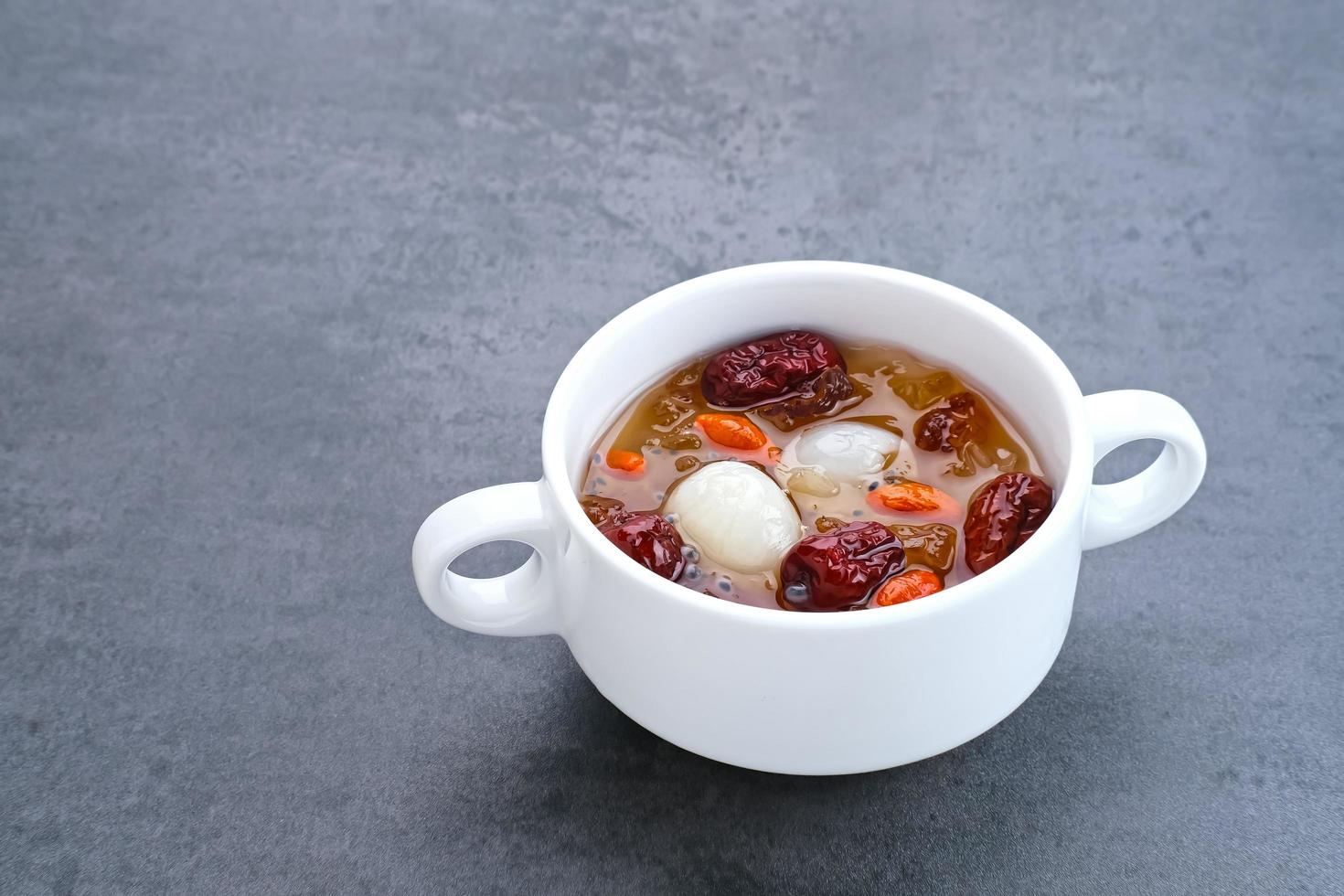 cocina china, un plato de chicle de durazno. El chicle de melocotón es una bebida tradicional china que contiene chicle de melocotón, nido de pájaro, dátiles rojos, hongo de la nieve, bayas de goji y azúcar de roca. foto