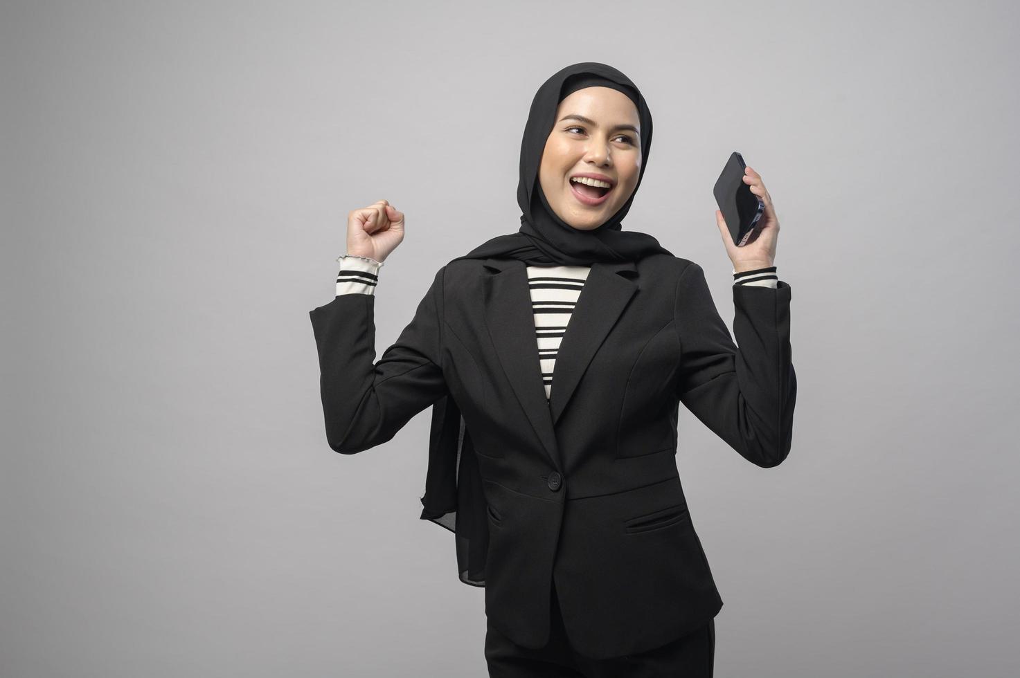 retrato de una mujer hermosa con hiyab usando un teléfono celular con fondo blanco foto