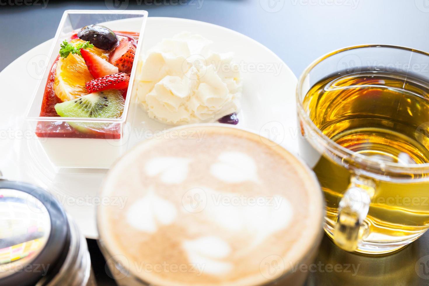 strawberry cream and a cup of tea and coffee on a wooden background, selective focus photo