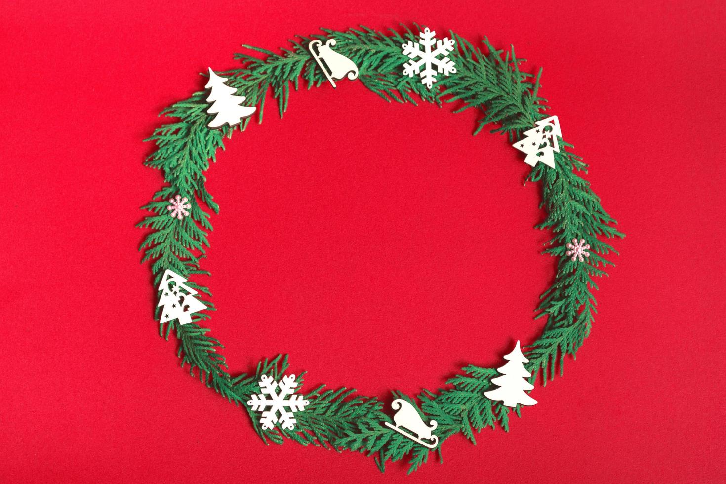 Christmas wreath of fir branches and decorations on a red background. Flat lay, top view, copy space. festive composition photo