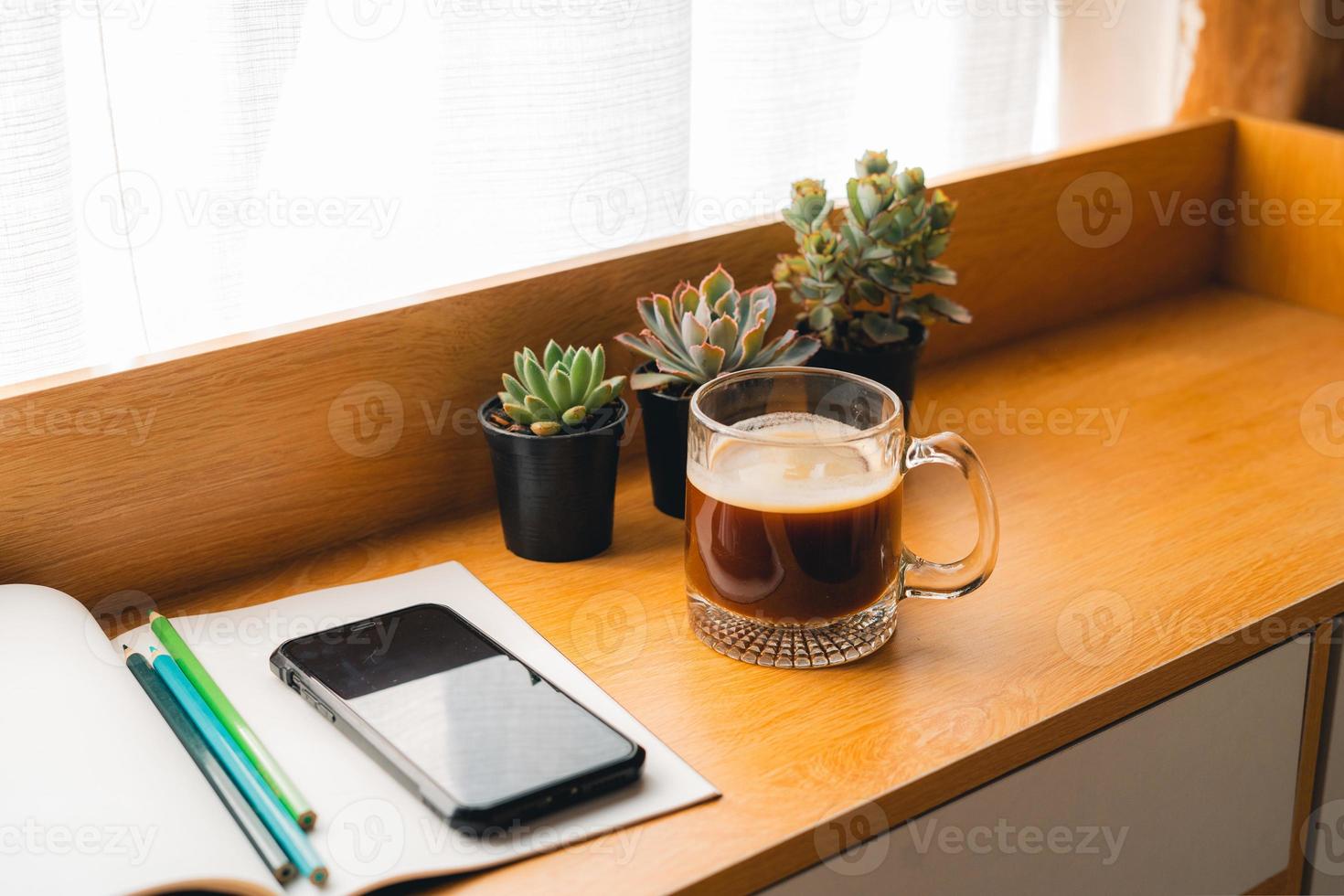 Coffee Morning,Coffee in a mug on a wooden table with a notebook photo