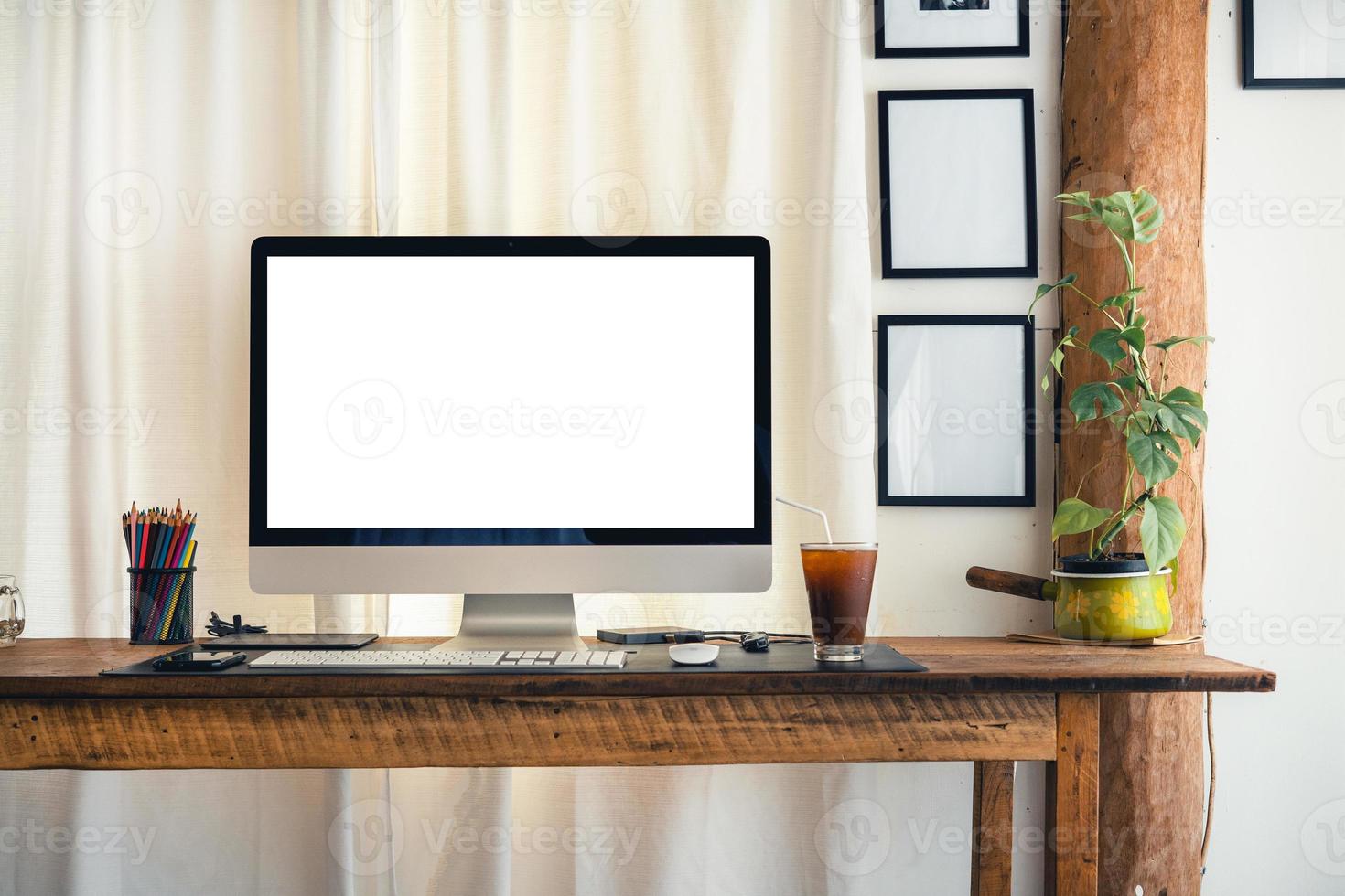 computadora en un escritorio en casa con cortinas blancas foto