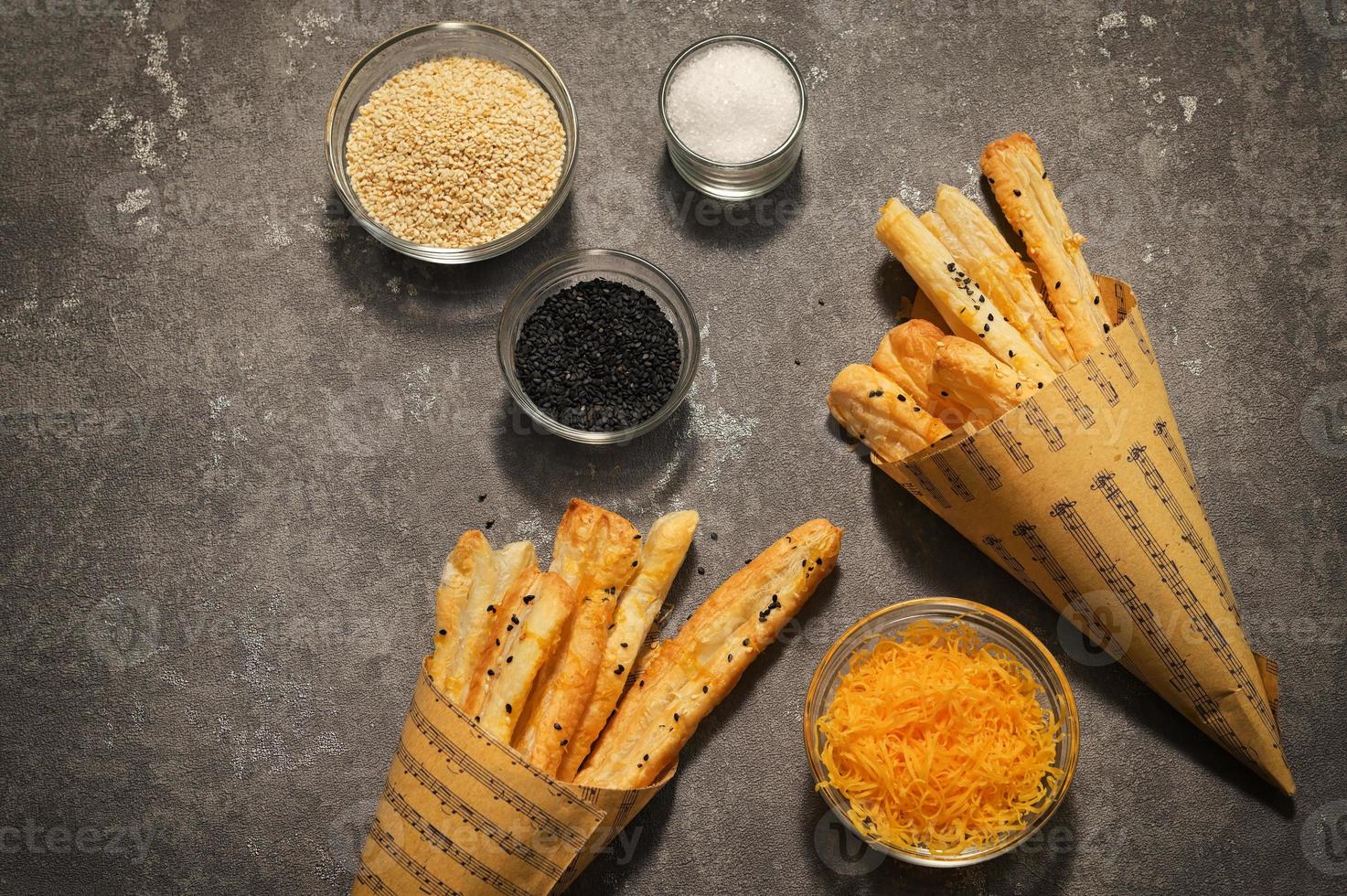 pajitas de queso y semillas de sésamo en un cono de papel foto