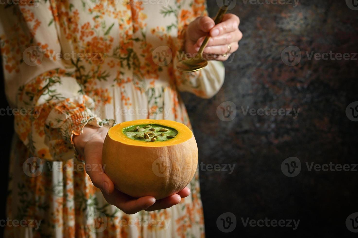 mujer sosteniendo sopa de crema de calabaza saludable foto