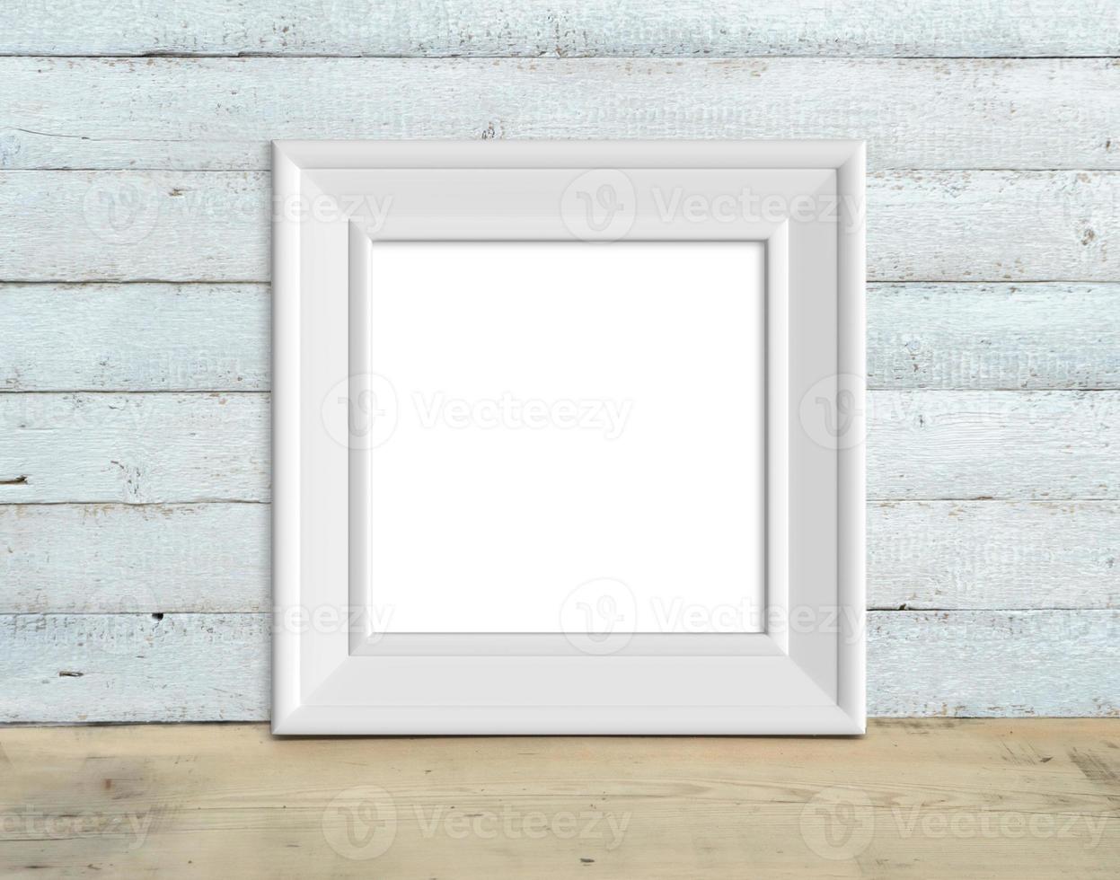 Square Vintage White Wooden Frame mockup stands on a wooden table on a painted white wooden background. Rustic style, simple beauty. 3d render. photo