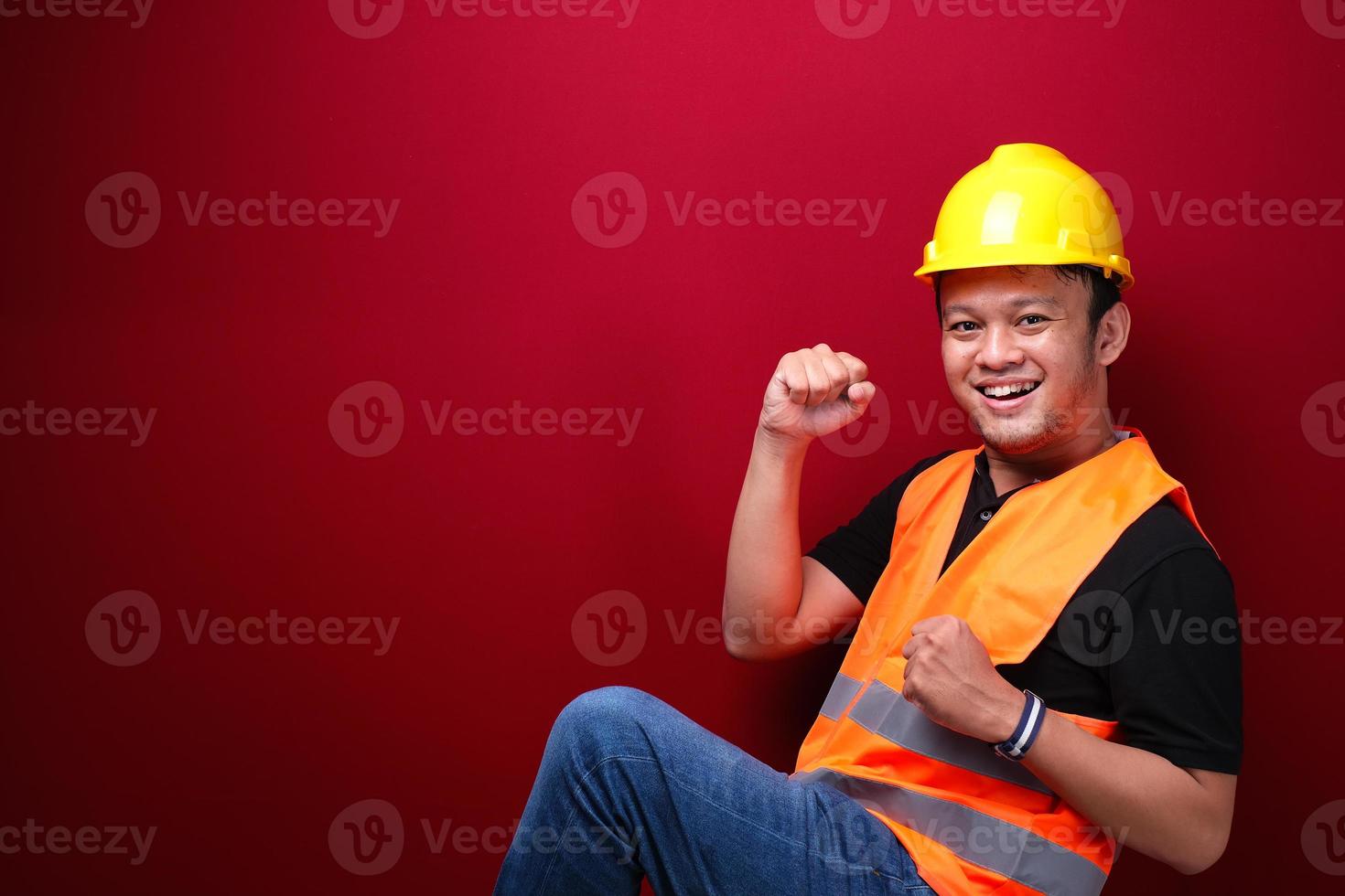 feliz, emocionado y sonriente, joven trabajador asiático levantando el brazo para celebrar el éxito o el logro. foto