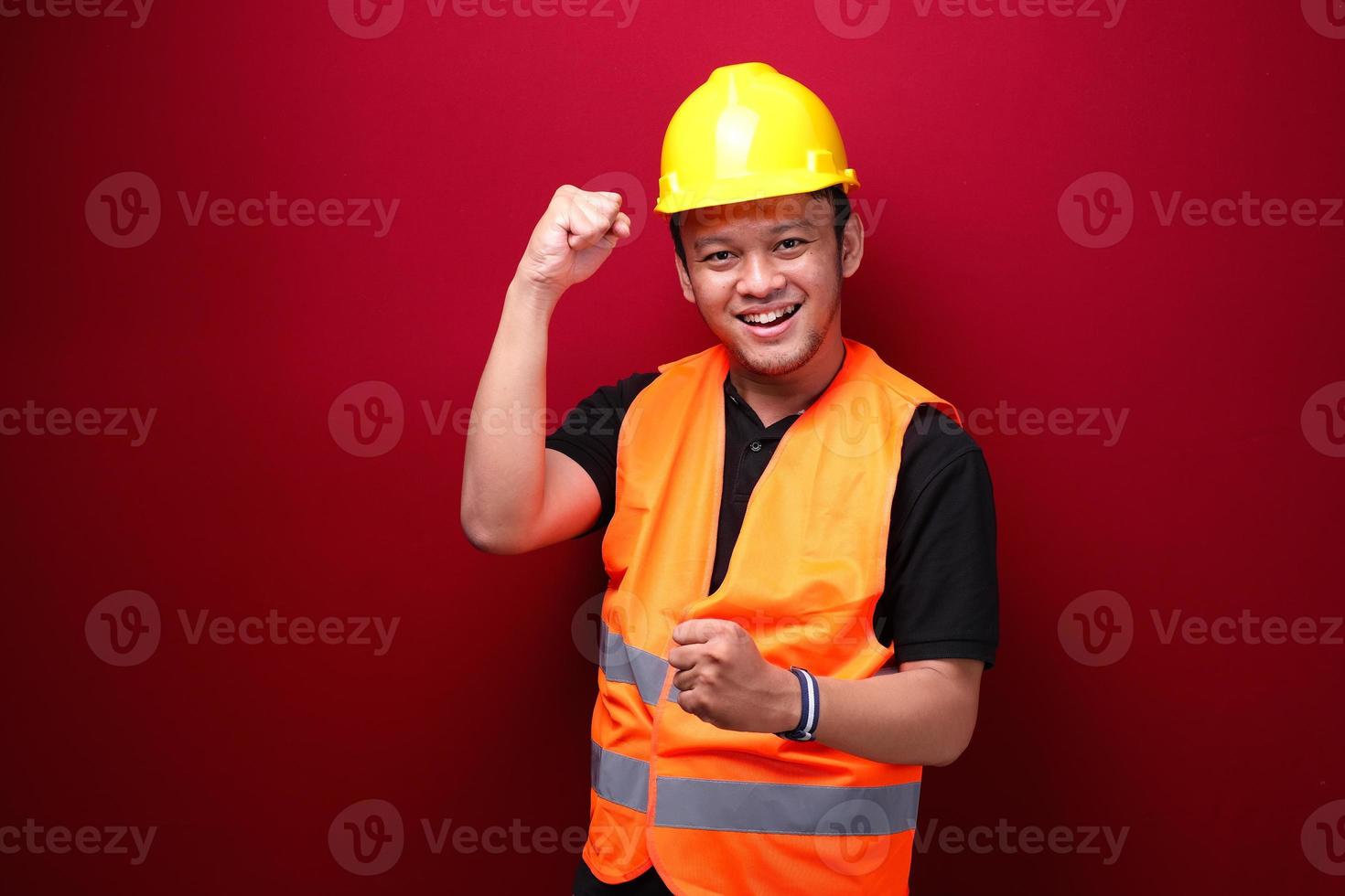 feliz, emocionado y sonriente, joven trabajador asiático levantando el brazo para celebrar el éxito o el logro. foto