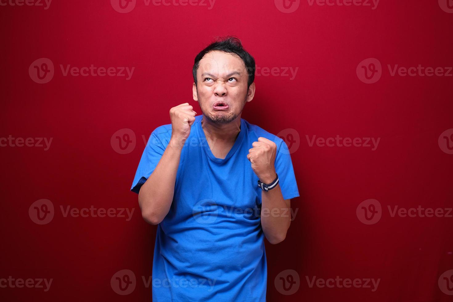 Angry and stress young Asian man raising his arm up. photo