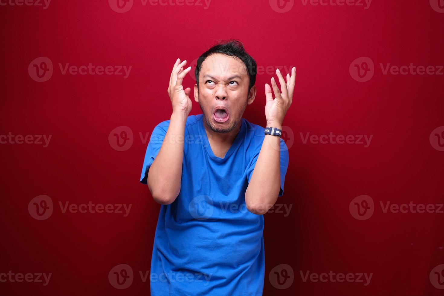 Angry and stress young Asian man raising his arm up. photo