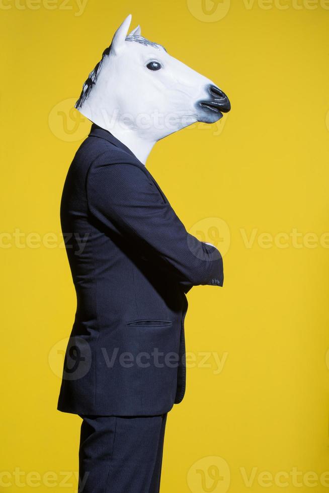 man with horse mask on yellow background photo