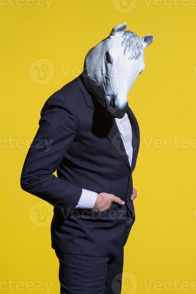 man with horse mask on yellow background photo