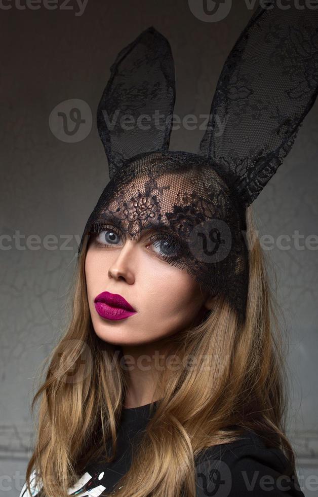 portrait of disproportionate, modern, stylish, fashionable sad woman after plastic surgery or after filters in photo edit application in bunny lace ears