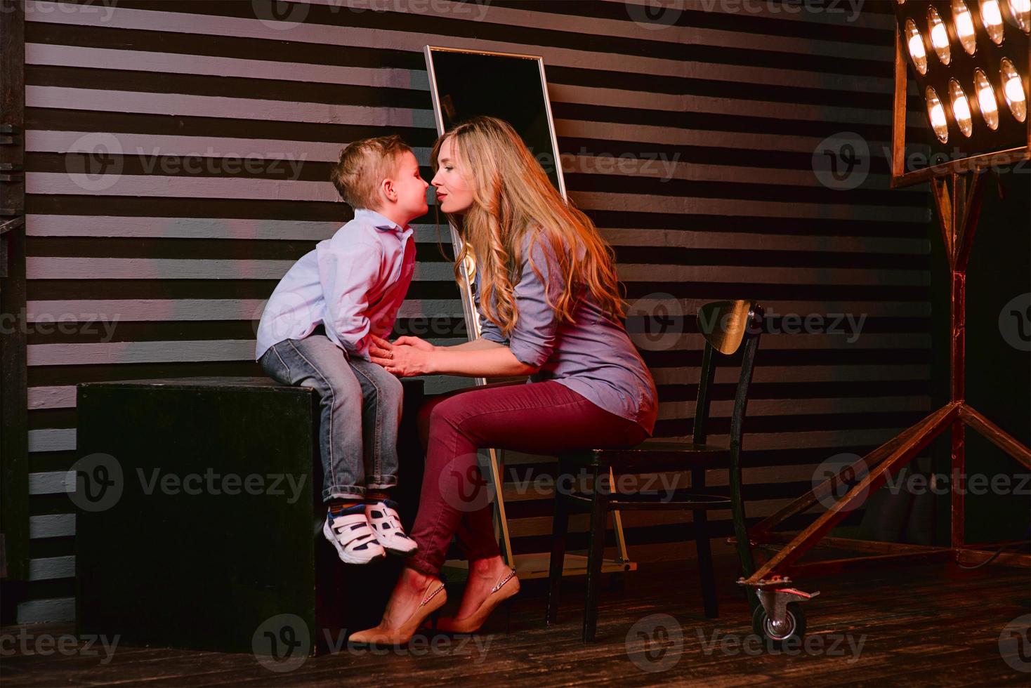 portrait of stylish cute little boy with beautiful mom in photo studio