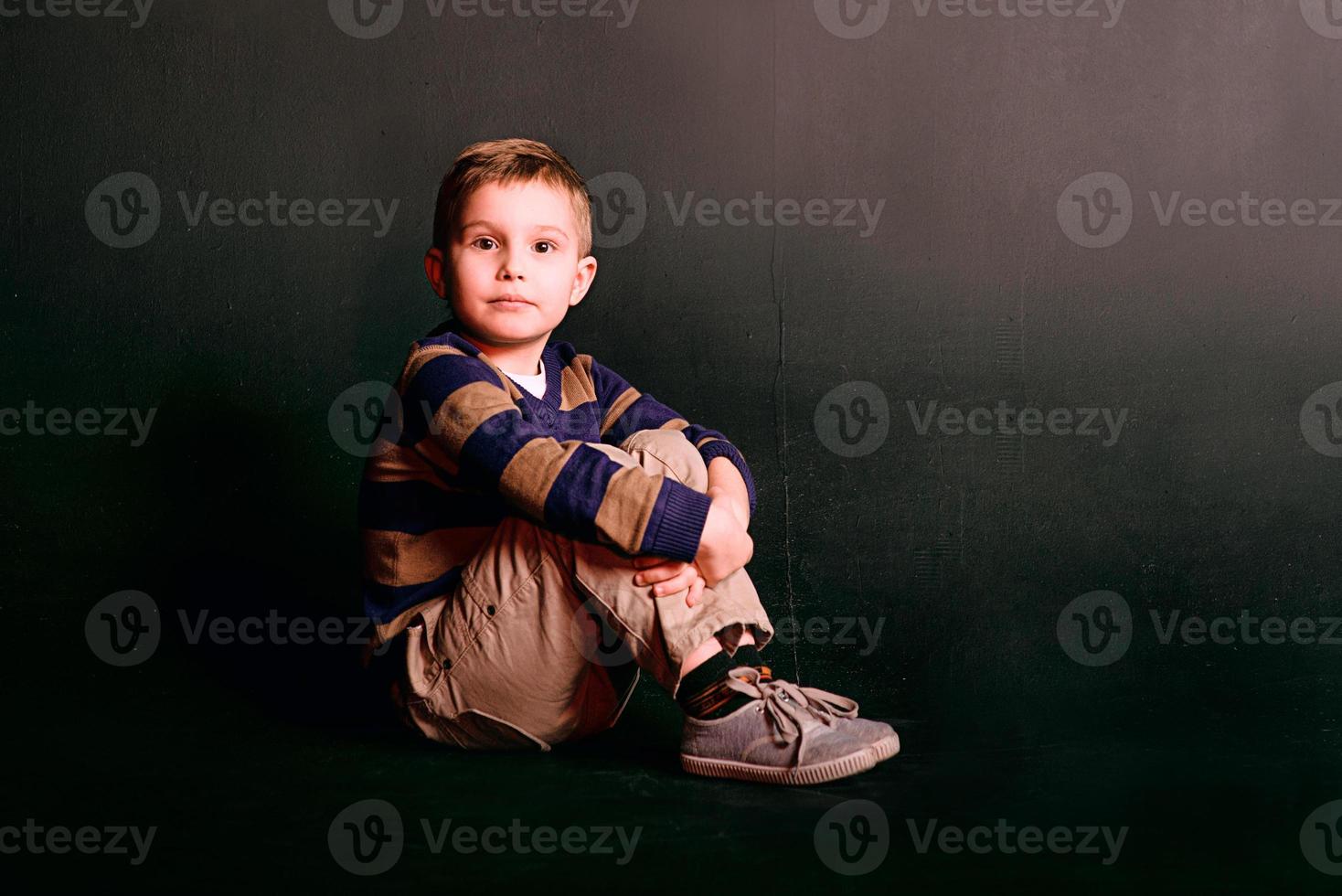 portrait of stylish cute little boy in photo studio