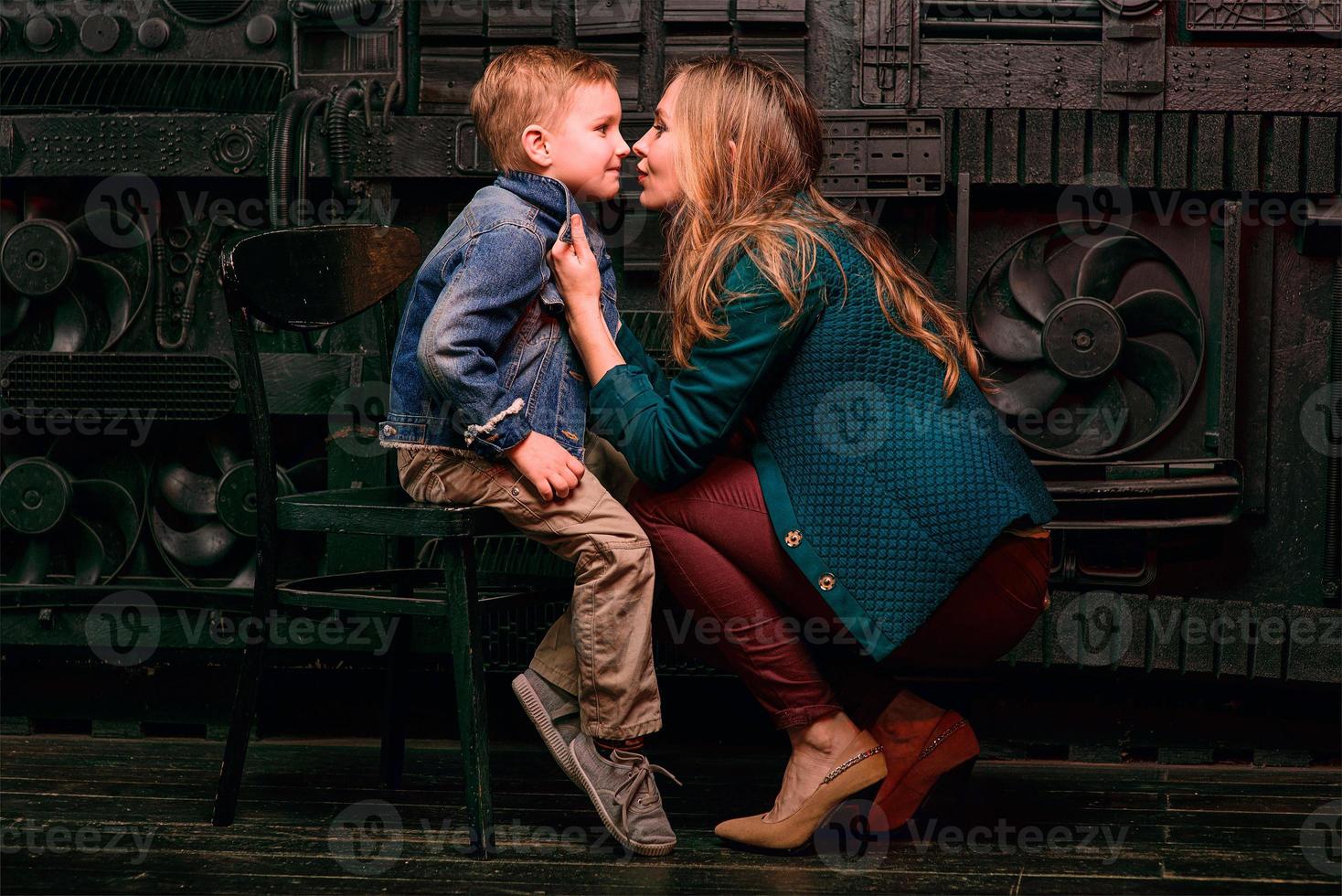 retrato de un niño lindo y elegante con una hermosa mamá en un estudio fotográfico foto