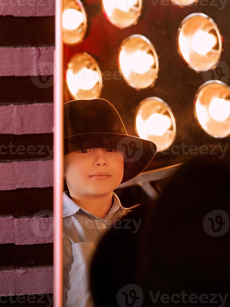 Stylish portrait of young boy in black hat in photo studio