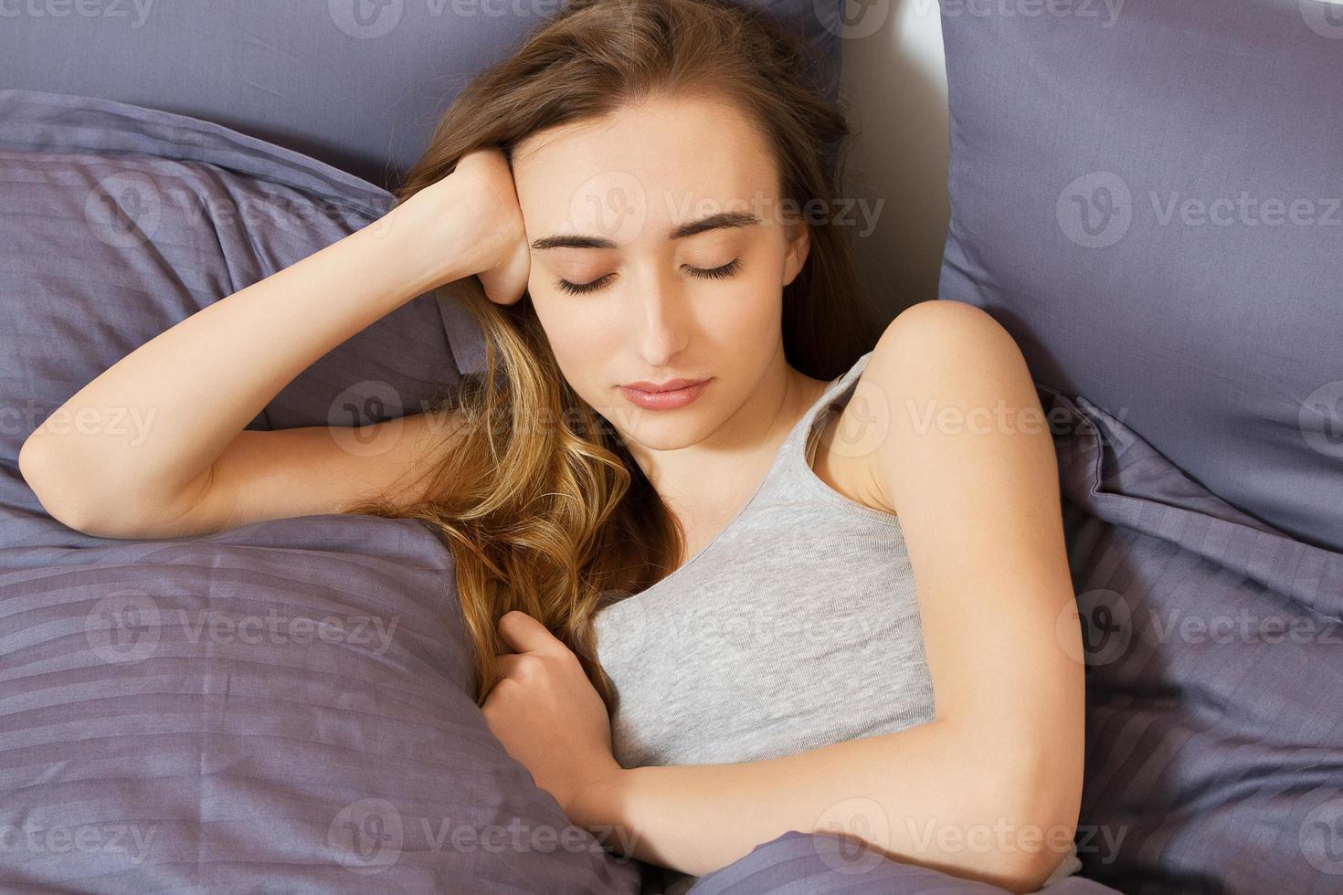 young beautiful woman sleeping on bed in bedroom photo