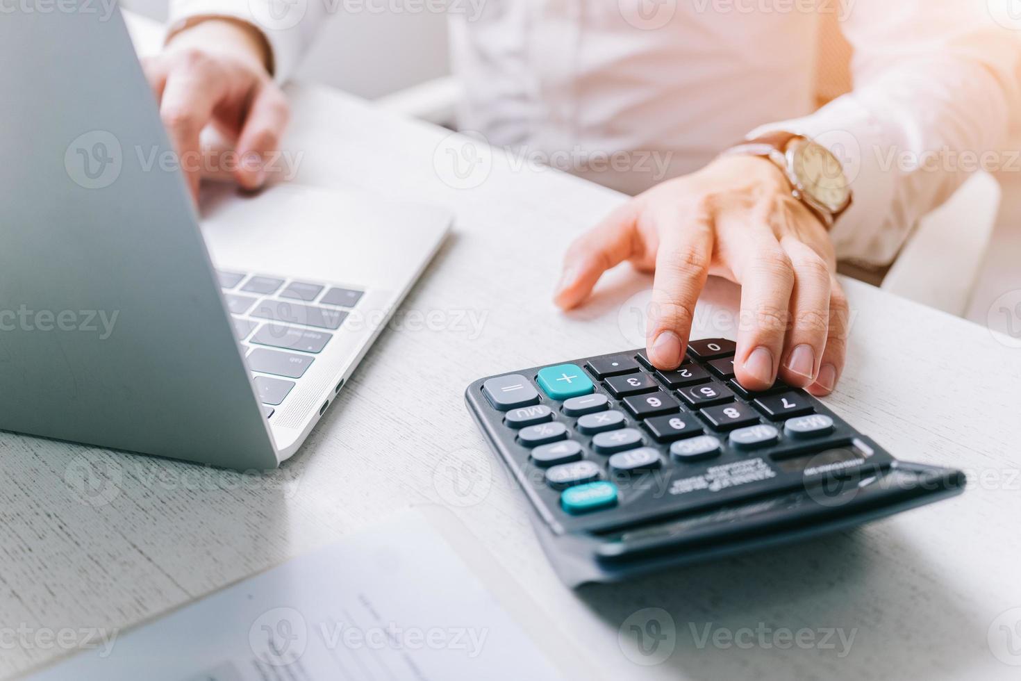 Asian Businessmen use a calculator to calculate tax and income photo