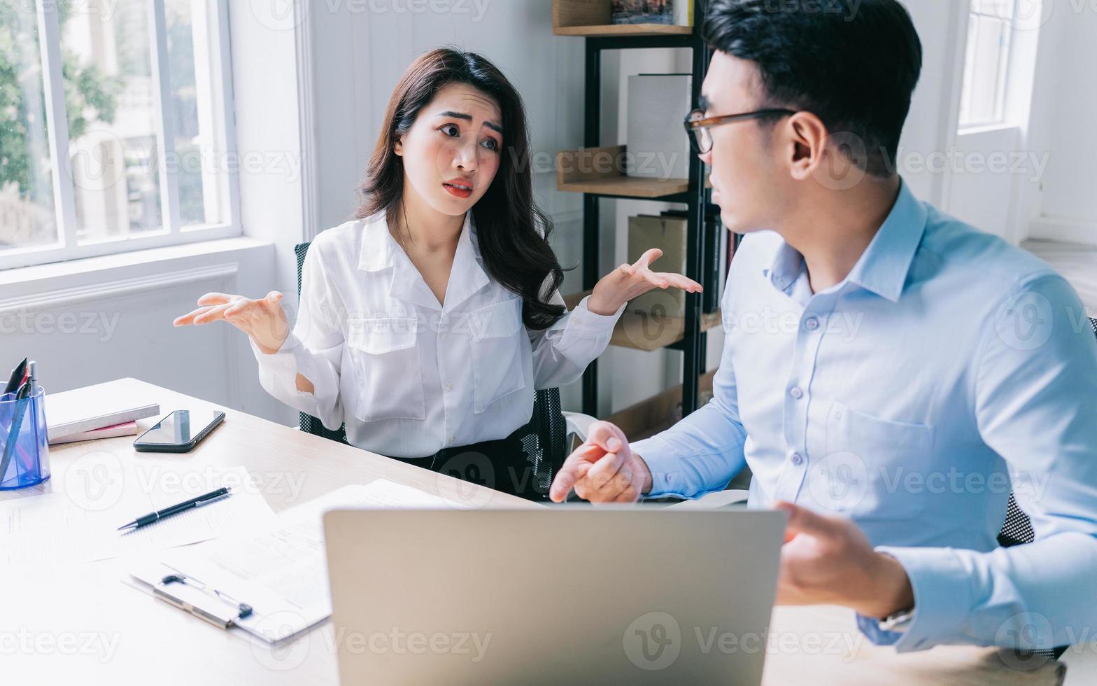Two Asian businesspeople working at office photo
