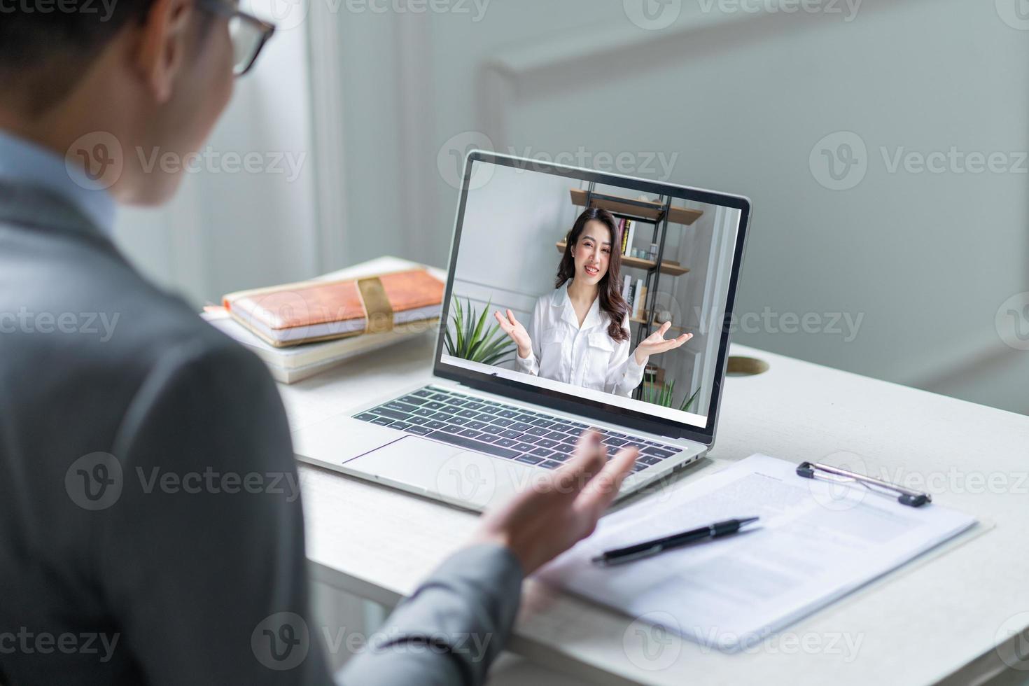 gerente masculino asiático entrevistando a candidatos de forma remota a través de videollamadas foto