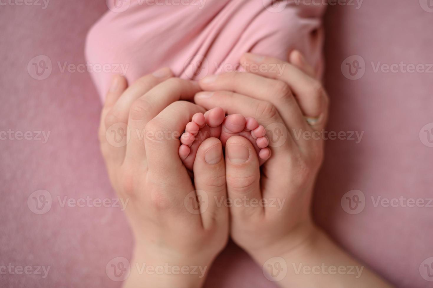 Small beautiful legs of a newborn baby in the first days of life photo