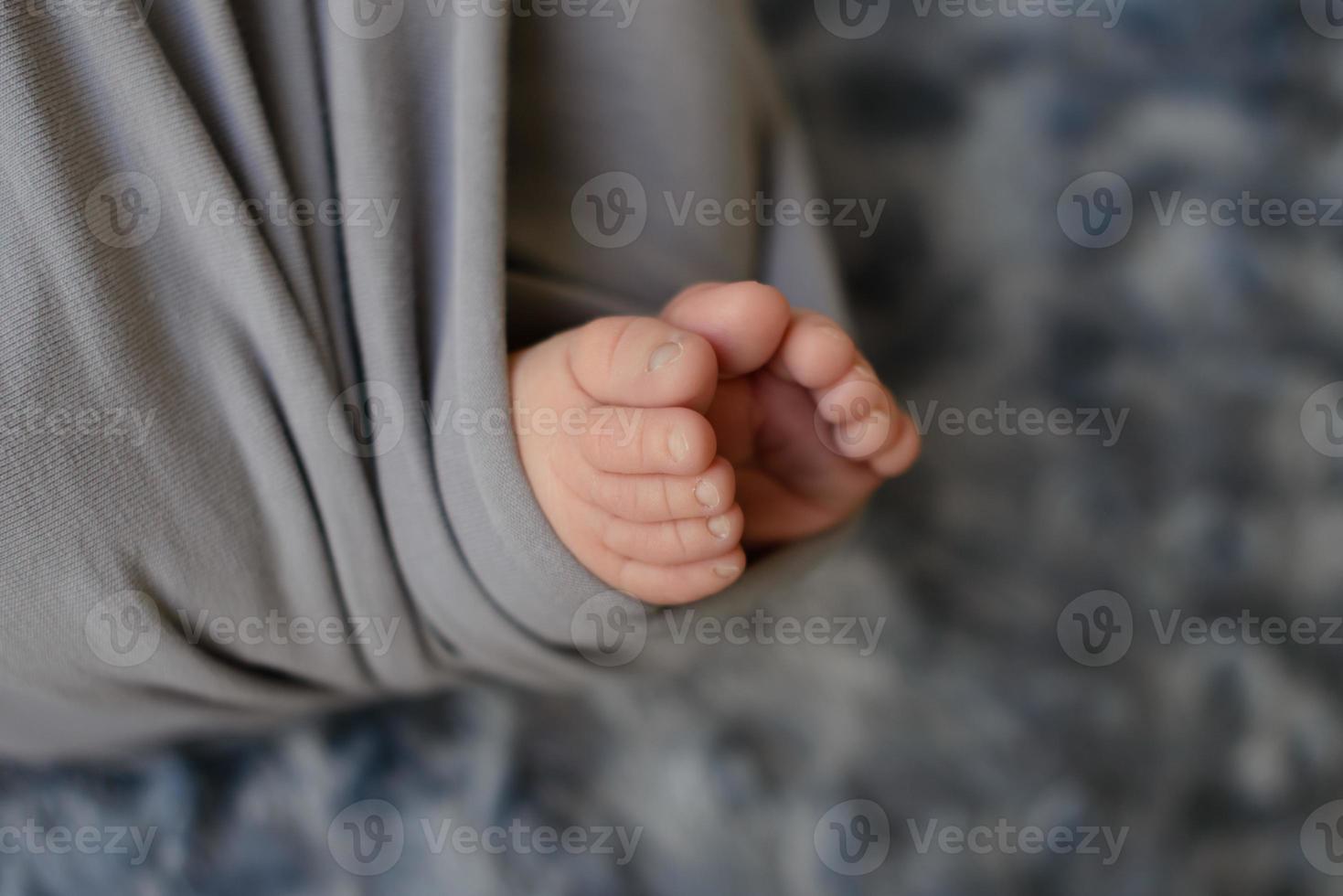 Small beautiful legs of a newborn baby in the first days of life photo