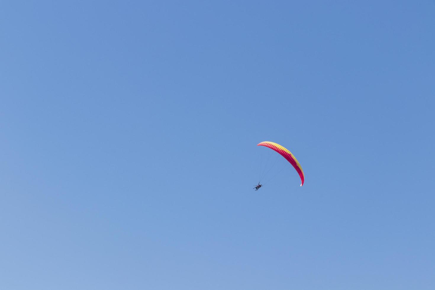 Colorful parachute aviator with blue sky. Paragliding photo