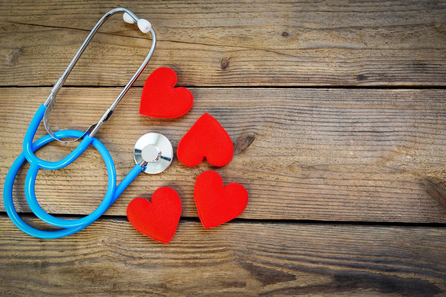 salud cardíaca y corazón rojo con estetoscopio sobre fondo de madera - día mundial del corazón día mundial de la salud o día mundial de la hipertensión y concepto de seguro de salud foto