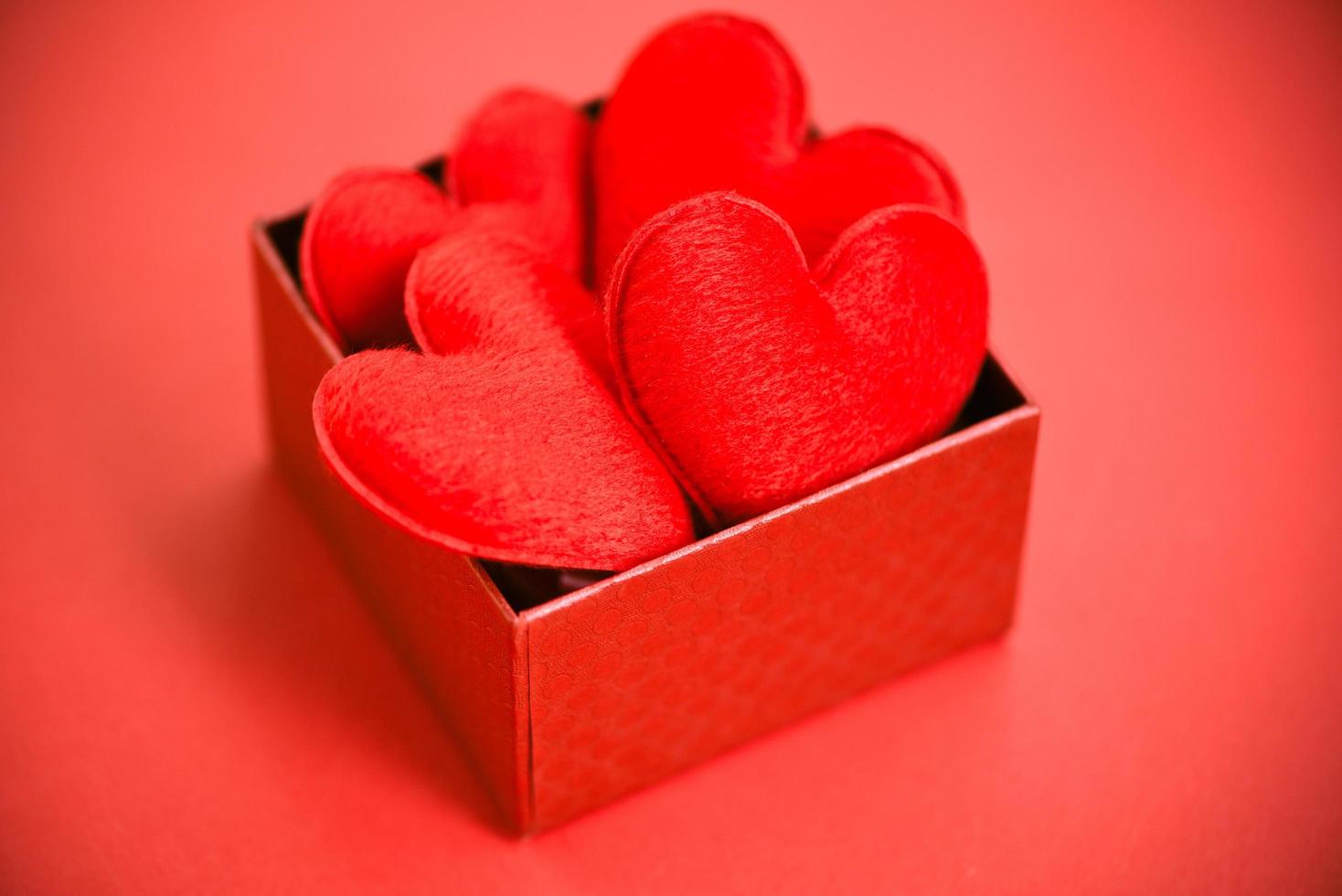 Open gift box with heart in red box surprise for gift to Merry Christmas Holiday Happy new year or romantic Valentines day on red background philanthropy donate help give love take care photo