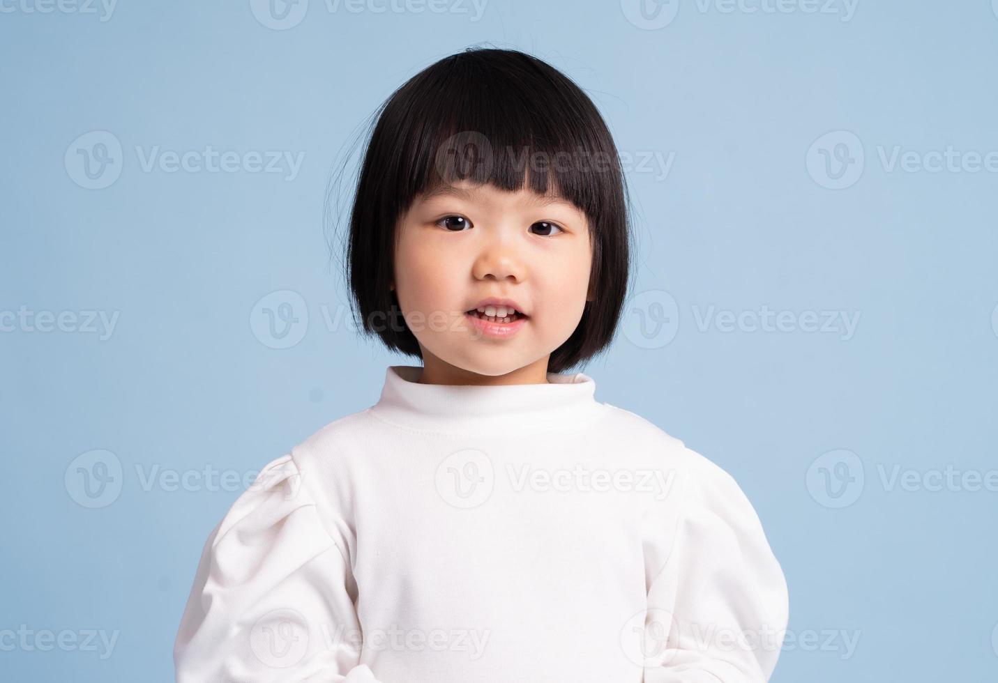 lovely baby girl portrait, isolated on blue background photo