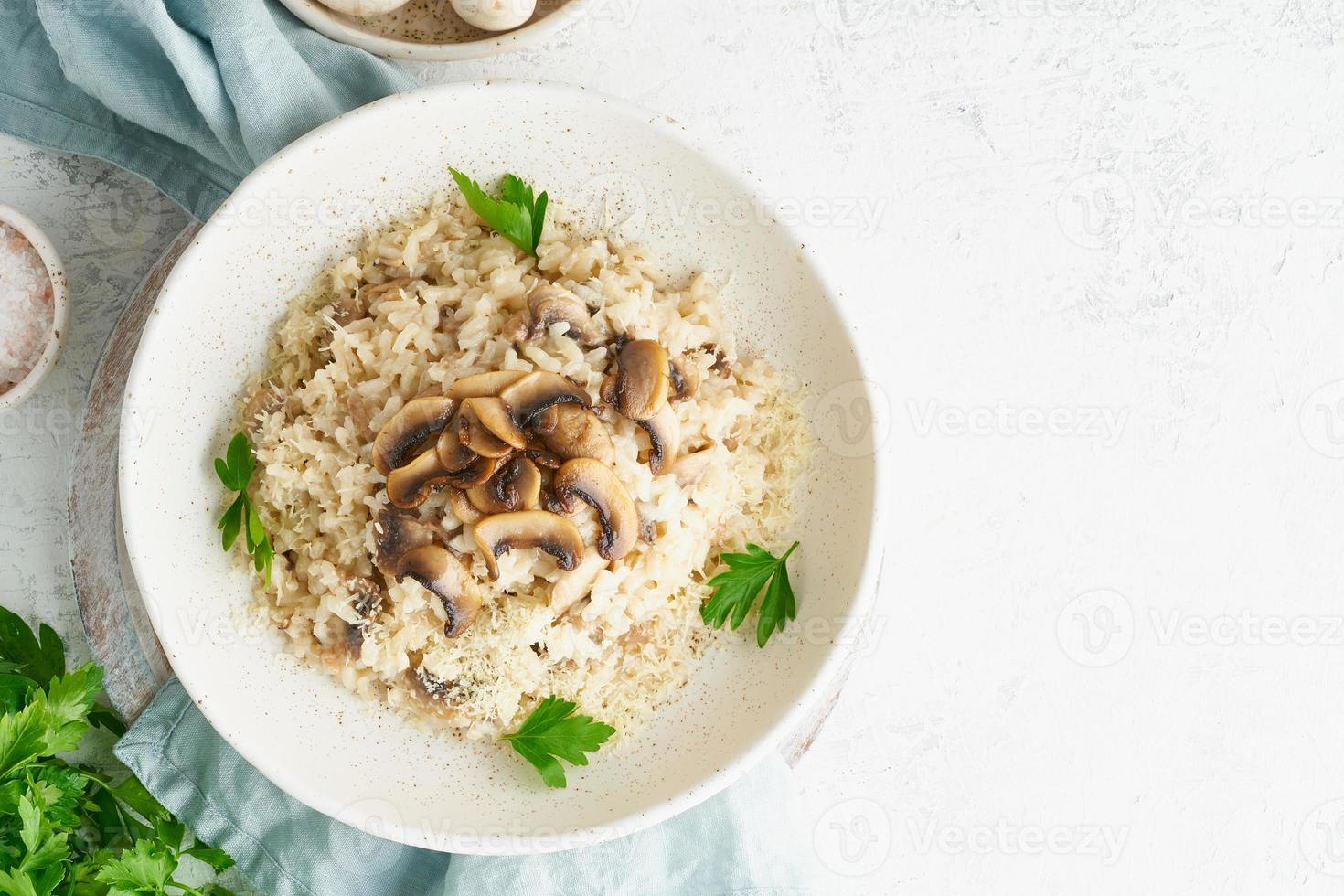 risotto con champiñones en plato. papilla de arroz con champiñones y perejil foto