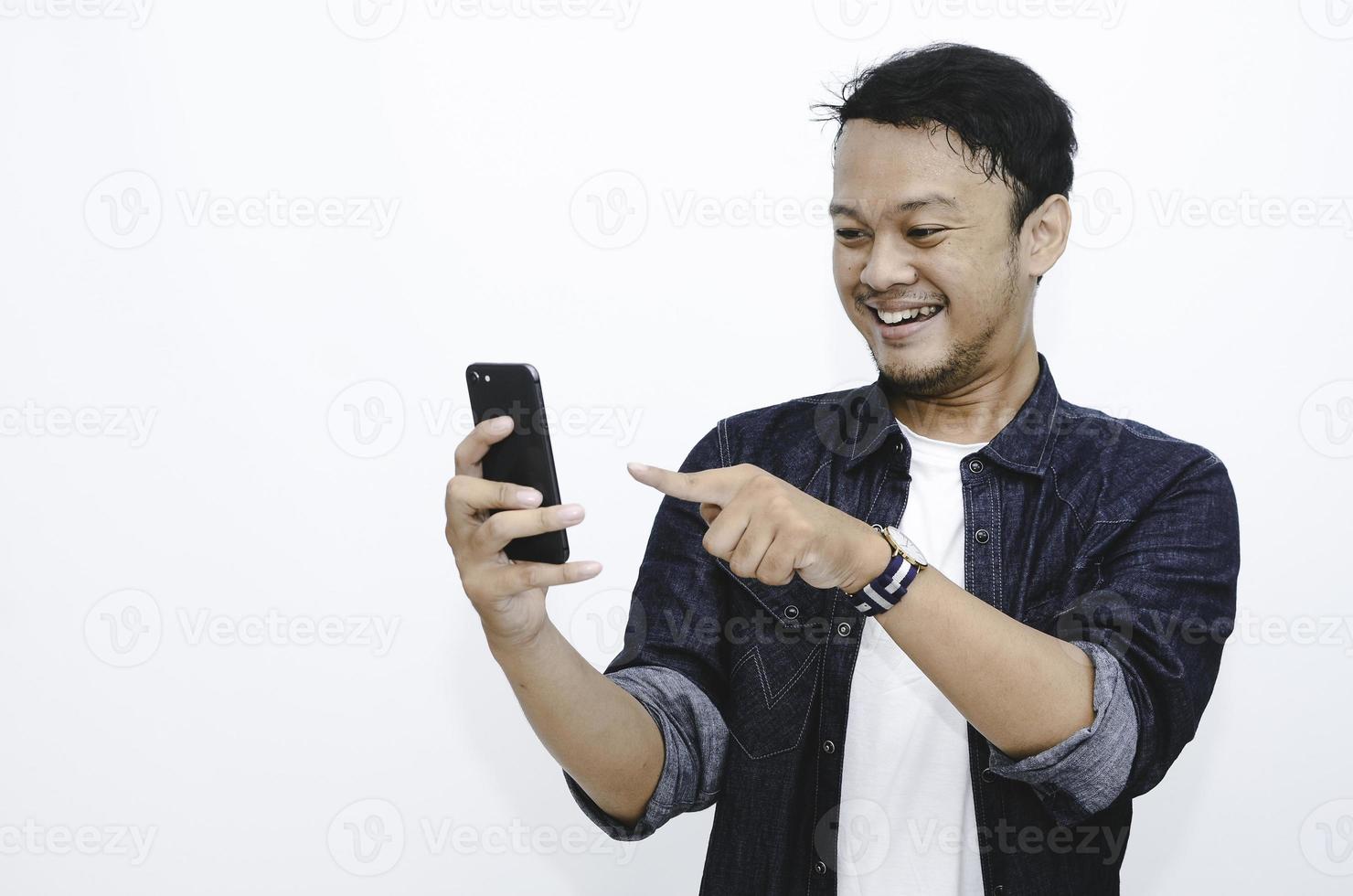 Smile and happy face of Young Asian man when playing game at phone in hand. photo