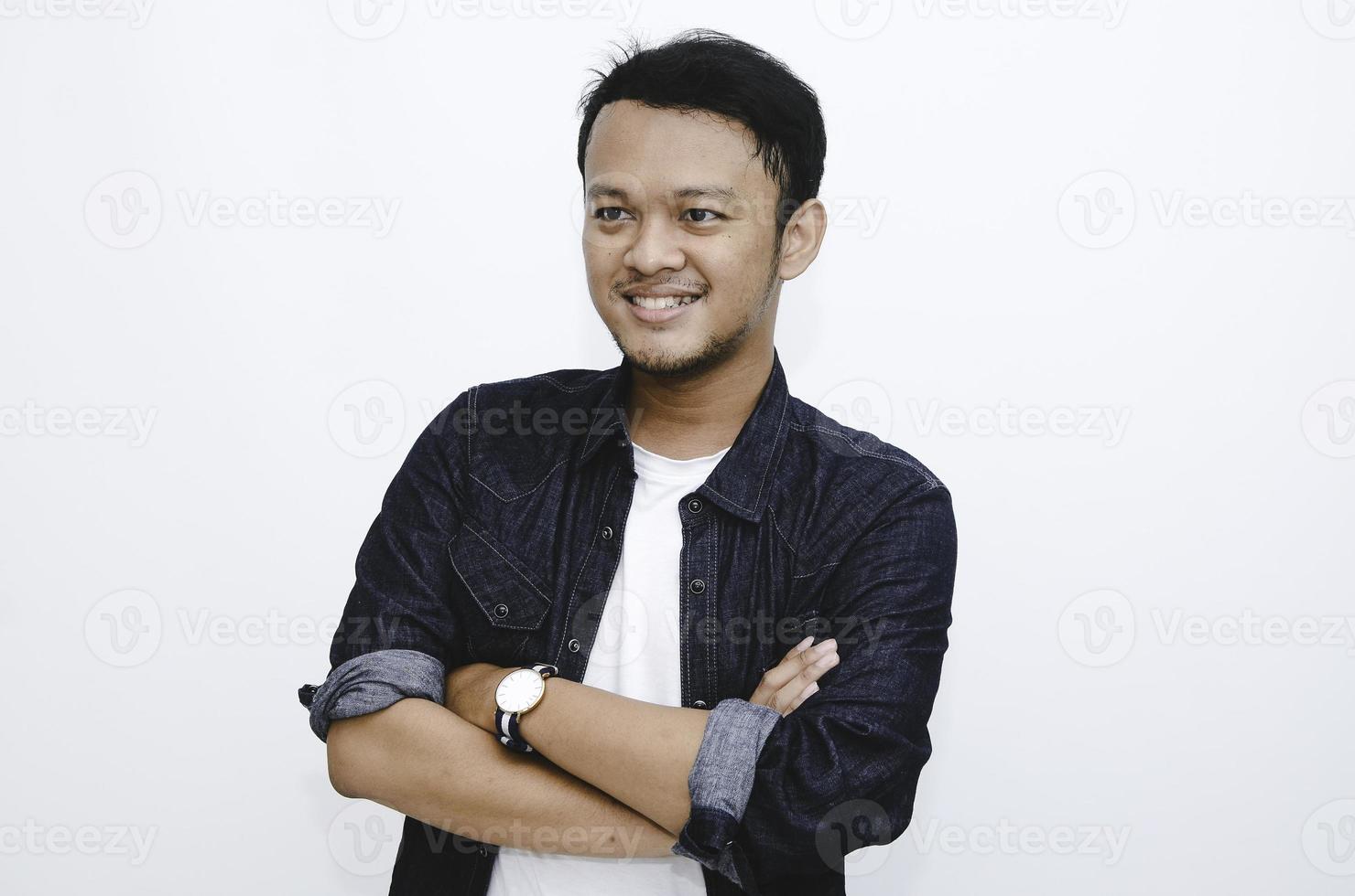 retrato de un joven asiático sonriente con camisa blanca y pantalón de mezclilla aislado en blanco. foto