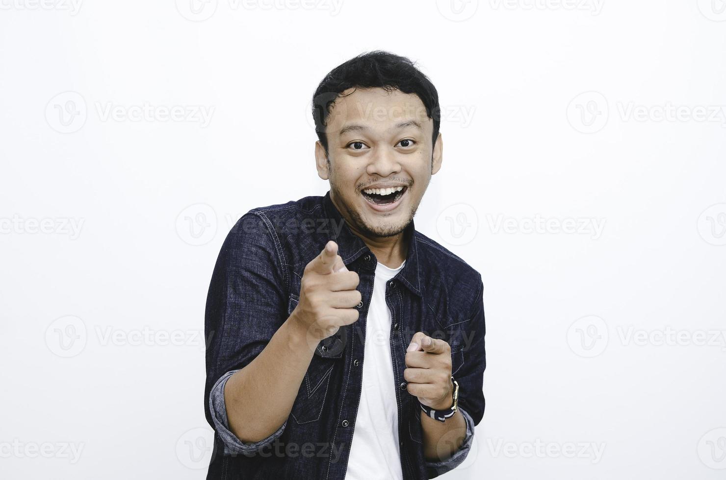 Asian young man pointing forward, Looking at Camera, make choosing you gesture against white background photo