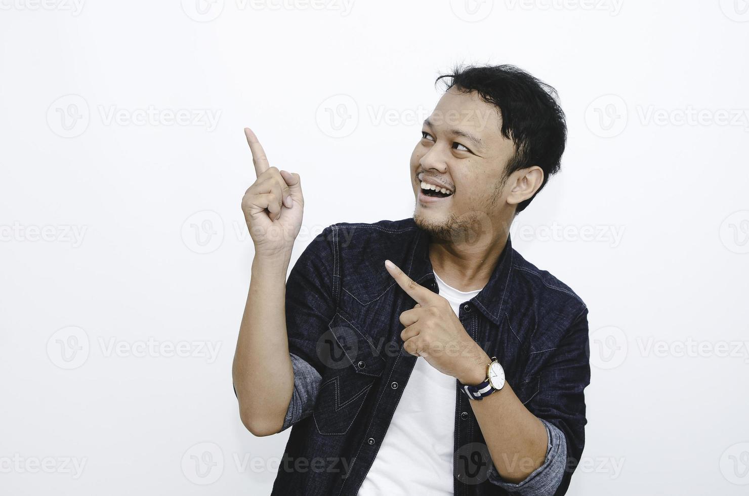 Smile of Young Asian man in white shirt with hand point on empty space photo