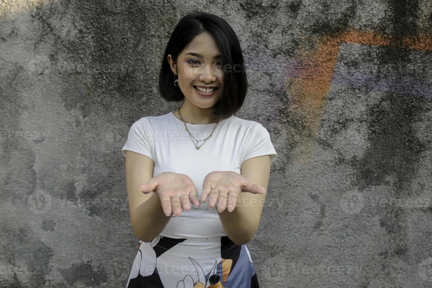 Smile Asian women smiling show palm in front for present photo