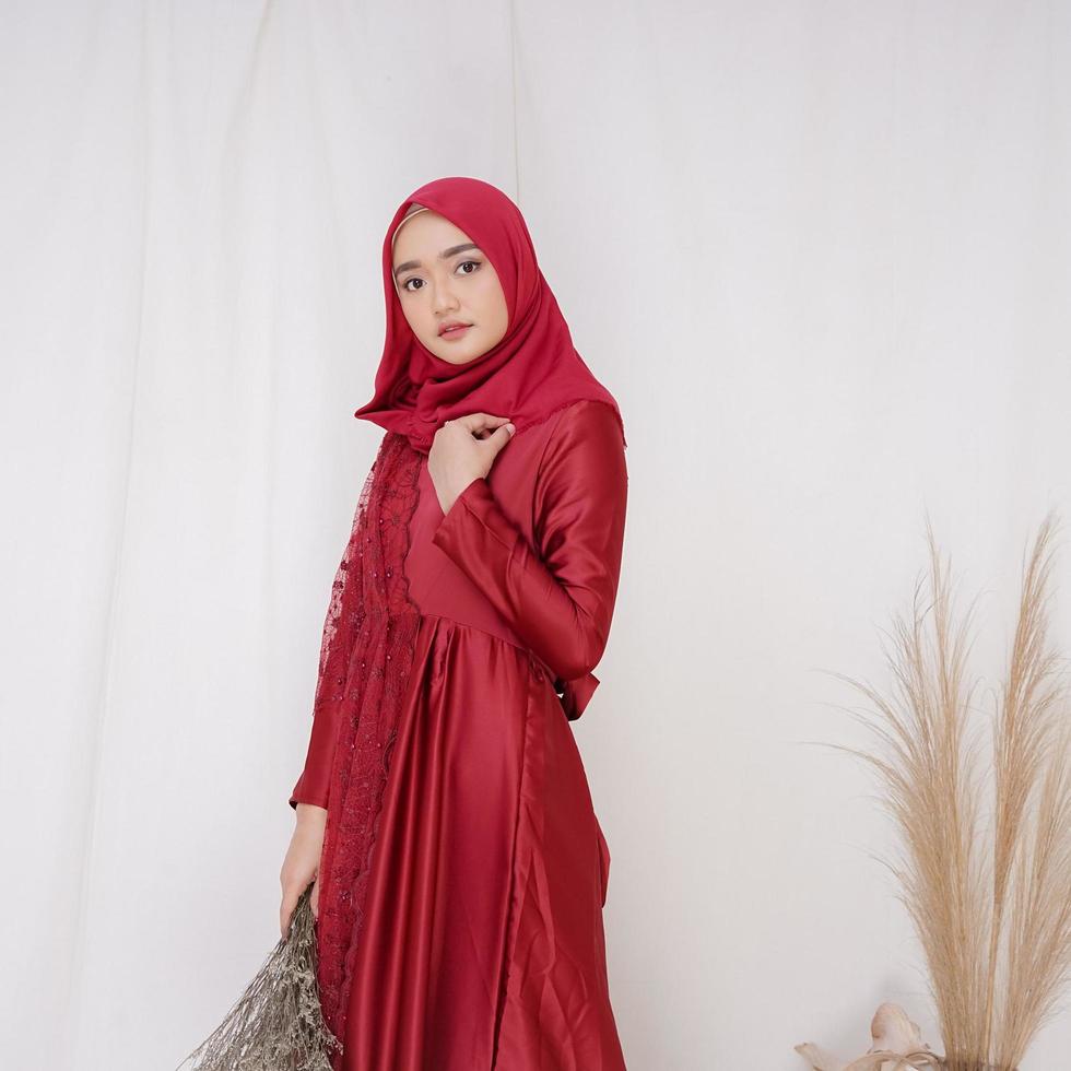 hermosa modelo de mujer islámica que lleva la moda hijab, un traje de estilo de vida moderno para la mujer musulmana. concepto un vestido de novia, belleza o eidul fitri. Una modelo de niña asiática con hiyab en sesión de fotos en interiores