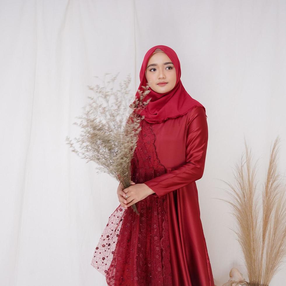 hermosa modelo de mujer islámica que lleva la moda hijab, un traje de estilo de vida moderno para la mujer musulmana. concepto un vestido de novia, belleza o eidul fitri. Una modelo de niña asiática con hiyab en sesión de fotos en interiores