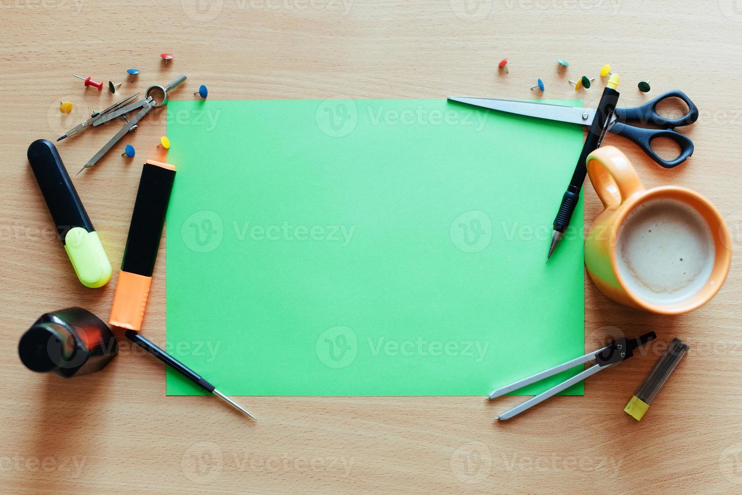 Green empty sheet with lots of stationery objects makes photo