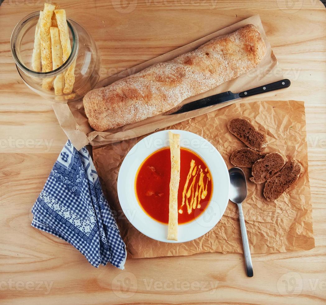 Fresh tomato soup in a white mask with bread baguette photo