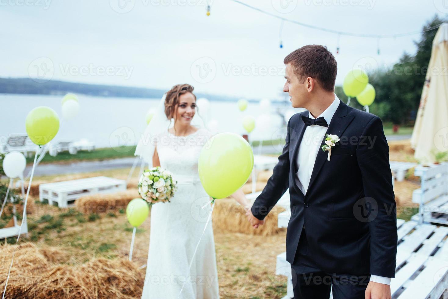 beautiful young wedding couple kissing , blonde bride with flowe photo