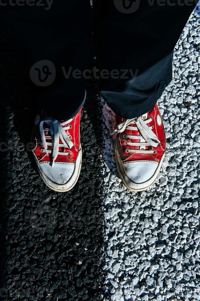 pair red shoe on the pavement. Black asphalt texture photo