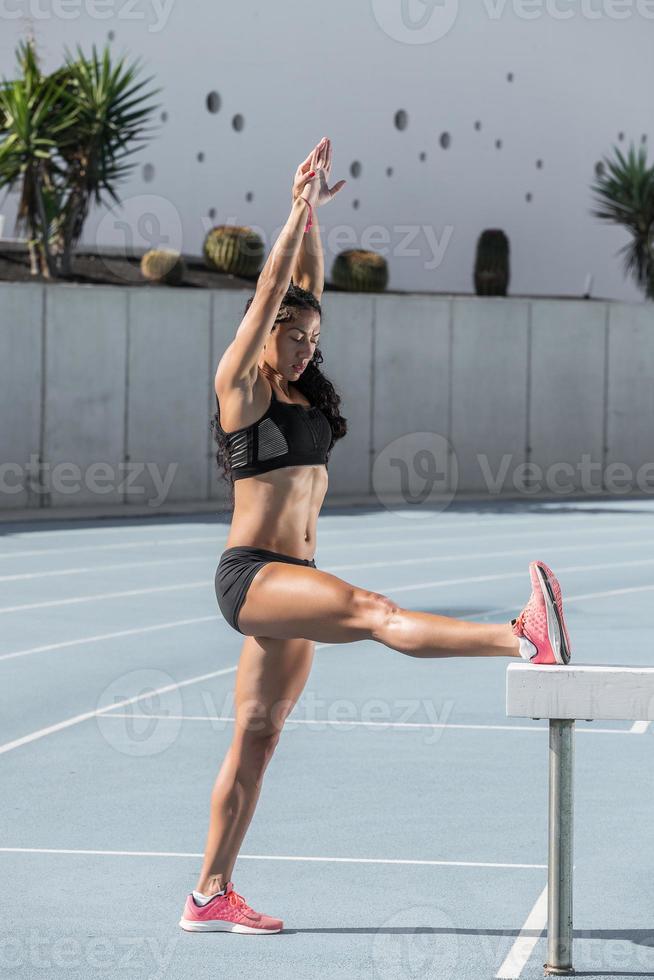 Female athlete training on athletics track photo