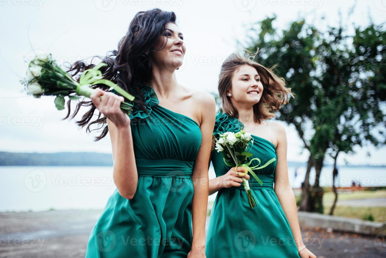 Happy young women at a wedding with bouquets of flowers photo