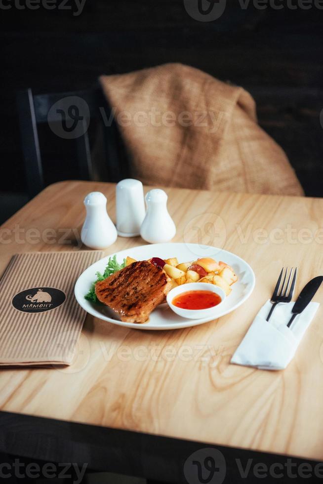 Steak with crispy golden fries and tomato spicy sauce photo