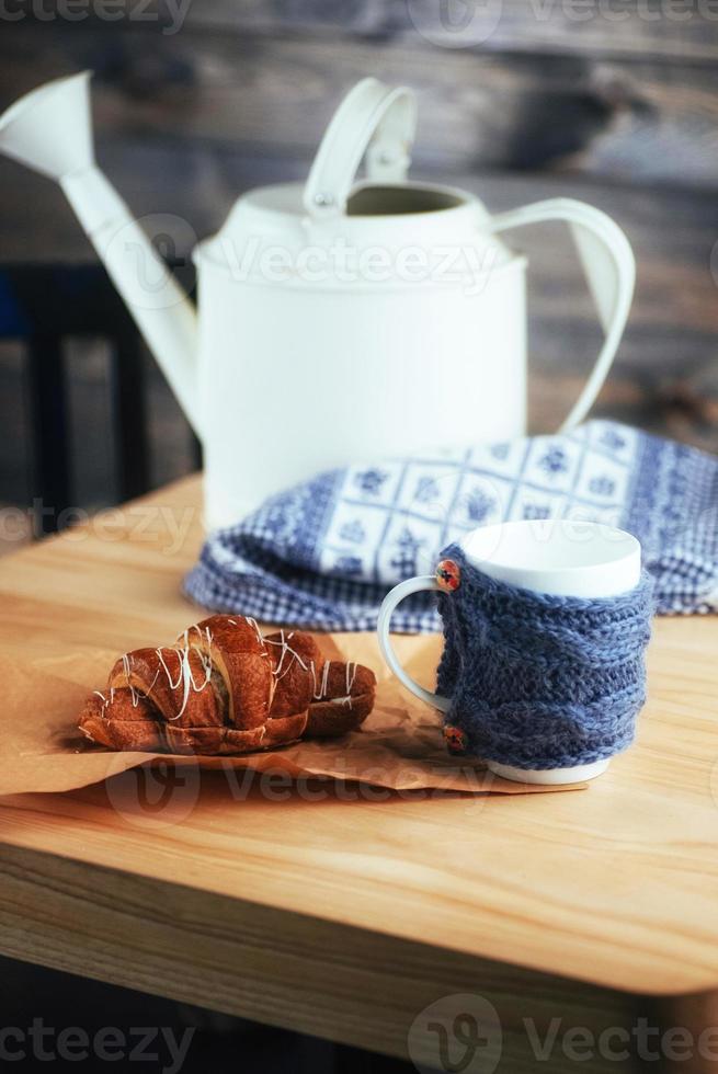 Pouring tea into cup of on the wooden table photo